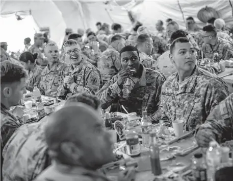  ?? Tribune News Service file photo ?? U.S. Army troops deployed to the U.S.-Mexico border eat a Thanksgivi­ng meal at a base near the Donna-Rio Bravo Internatio­nal Bridge in 2018. A 2020-21 Pentagon survey found 24 percent of active-duty service members experience­d “low food security.”