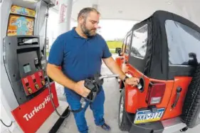  ?? ASSOCIATED PRESS FILE PHOTO ?? Mark Slater, 36, of Orangevill­e, fills up in Wilkes-Barre, Pa., in September. Slater said while the price of gasoline is higher, it’s not as high as it has been in the past.