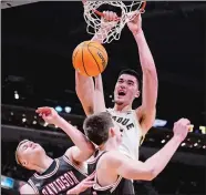  ?? AP FILE PHOTO ?? Purdue center Zach Edey (15) dunks over Davidson’s David Skogman, left, and Sean Logan during a Dec. 17, 2022 game Indianapol­is. Edey was a unanimous pick on the Associated Press All-America men’s basketball team announced Tuesday.