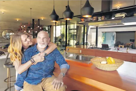  ?? Genaro Molina Los Angeles Times ?? TIFFANY ROCHELLE and husband Paul Hibler enjoy a warm moment in their Venice home’s kitchen, which is overscale so he can cook with family and friends.