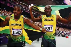  ?? — Reuters ?? Friend and foe: Jamaica’s Usain Bolt is now focused on defending his 200m title despite the threat from training partner Yohan Blake (left).