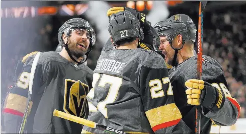  ?? Erik Verduzco Las Vegas Review-journal @Erik_verduzco ?? Defenseman Shea Theodore (27) shares high-fives and helmet taps with teammates Alex Tuch, left, andPaul Stastny after scoring Saturday night in the third period for a 3-0 lead against the Nashville Predators.The Knights won 5-1 to end a five-game losing streak on home ice.