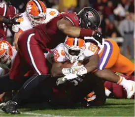  ??  ?? Tavien Feaster ( 28) of Clemson plows under South Carolina tackler Ulric Jones to score a touchdown. Feaster’s one- yard plunge put the Tigers up 14- 0.
| STREETER LECKA/ GETTY IMAGES