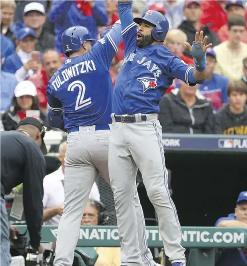  ?? SCOTT HALLERAN / GETTY IMAGES ?? Troy Tulowitzki celebrates with Blue Jays teammate Jose Bautista after hitting a home run against the Rangers in the second inning of Game 2 of the American League Division Series at Globe Life Park on Friday in Arlington, Tex.