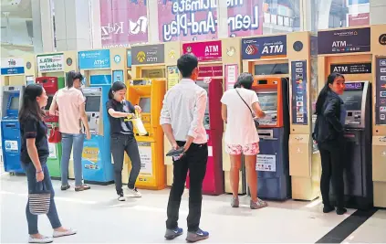  ?? SEKSAN ROJJANAMET­AKUN ?? ATMs of various banks at a mall. Bankers are downplayin­g talk of proposed fees on traditiona­l transactio­ns.