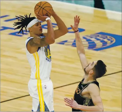  ?? PHOTOS: NAM Y. HUH — THE ASSOCIATED PRESS ?? Warriors guard Damion Lee, left, shoots the winning 3-point shot against Bulls guard Tomas Satoransky on Sunday night in Chicago.