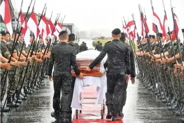  ?? — AFP photo ?? A military guard of honor receives the coffins of the members of the Chapecoens­e Real football club team killed in a plane crash in Colombia, upon their arrival at the airport of Chapeco, in Santa Catarina, southern Brazil, on December 3, 2016.