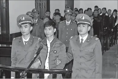  ??  ?? Vietnamese blogger, Nguyen Van Hoa (midden) tijdens zijn gehoorzitt­ing waar hij tot 7 jaar gevangenis­straf veroordeel­d is wegens propaganda tegen de staat. (Foto: Chicagotow­nnews.com)