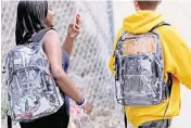  ?? JOHN MCCALL Sun Sentinel/TNS ?? Students wear clear backpacks outside of Marjory Stoneman Douglas High School in Parkland on April 2, 2018.