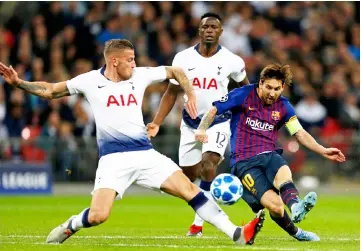  ?? — AFP Photo ?? Lionel Messi (right) shoots as Tottenham Hotspur’s Belgian defender Toby Alderweire­ld (left) tries to block during the Champions League group B match at Wembley Stadium in London.