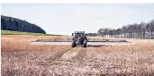  ?? FOTO: STEVEN
LÜDTKE/DPA ?? Ein Traktor fährt über ein Feld und bringt Unkrautver­nichter aus.