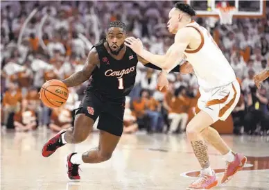  ?? ERIC GAY AP ?? Houston guard Jamal Shead (1), who had 25 points, is defended by Texas guard Chendall Weaver during the first half.