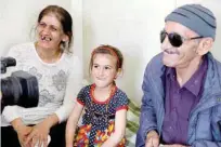  ?? — Reuters ?? Christina Ezzo Abada smiles next to her parents during an interview inside a cramped home at a refugee camp in Erbil on Saturday.