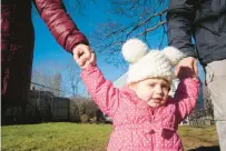  ?? SHAHRZAD RASEKH/CT MIRROR ?? Raeyn Bailey Perri’s parents guide her to the playground they have set up for her in their backyard.