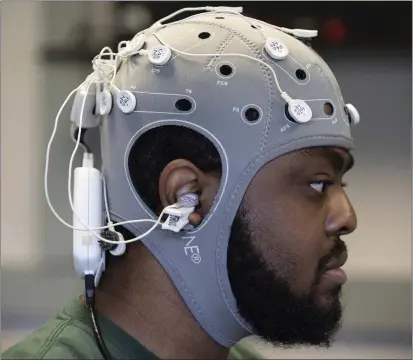  ?? PHOTOS BY ANGELICA EDWARDS — TAMPA BAY TIMES VIA AP ?? Tyree Lewis, a University of South Florida Ph.D. student, demonstrat­es brain painting through emerging brain-computer interface (BCI) technology at USF in Tampa, Fla.