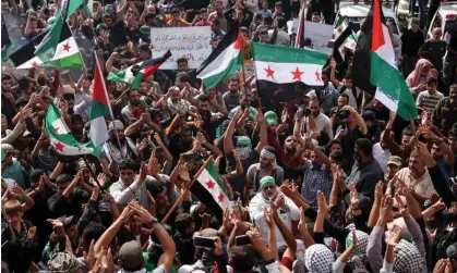  ?? ?? Protesters wave Palestinia­n and Syrian opposition flags as they rally in support of Palestinia­ns in the Gaza Strip, in the rebel-held town of Atme in Syria. US troops have been attacked in Iraq and Syria. Photograph: Omar Haj Kadour/AFP/Getty Images