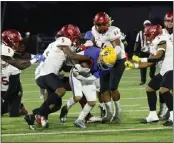  ?? PHOTO BY TRACEY ROMAN ?? La Mirada's Martin Aguilera tries to break free from Dominguez's Jayden Urbina, left, and Peaire Alexander in the Matadores' 21-14victory over the Dons.