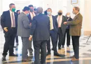  ?? KIM HAIRSTON / BALTIMORE
SUN ?? Maryland Delegates who did not reserve
seats in either the chamber or auxiliary chamber wait in the lobby of the State House on the first day of the Maryland General Assembly. This session because of the
COVID-19 pandemic delegates could not be
seated together.