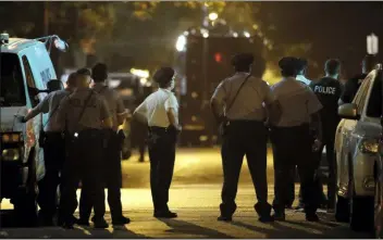  ?? MATT ROURKE — THE ASSOCIATED PRESS ?? Policer officers watch as a gunman is apprehende­d following a standoff Wednesday in Philadelph­ia.