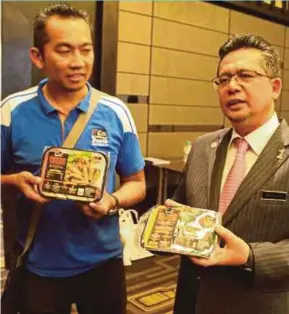  ??  ?? Terengganu Menteri Besar Datuk Seri Ahmad Razif Abdul Rahman (right) with samples of the frozen nasi dagang after a signing ceremony in Perth, Australia.