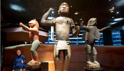  ?? ?? Un visiteur regarde des statues royales en bois du royaume du Dahomey, dans l'actuel Bénin, datées du XIXème siècle, au musée du Quai Branly à Paris en 2018.