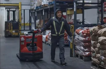  ?? Associated Press ?? A client walks through the onion department Tuesday at S. Katzman Produce, inside the Hunts Point Produce Market in the Bronx borough of New York.