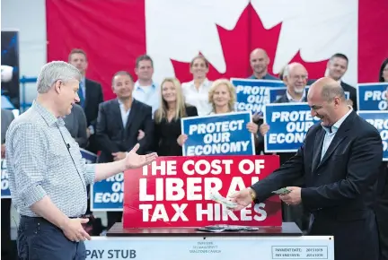  ?? JONATHAN HAYWARD/THE CANADIAN PRESS ?? Conservati­ve Leader Stephen Harper reacts as Dino Ari lays a pile of cash on the counter to illustrate the cost of proposed Liberal tax hikes during a campaign event at William F. White Internatio­nal in Etobicoke, Ont. on Tuesday.