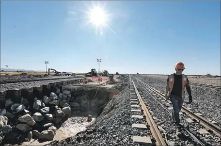  ?? Photograph­s by Irfan Khan Los Angeles Times ?? FILI VENEGAS walks along tracks near Niland, Calif., where a muddy spring is moving faster through dry earth than it previously had.