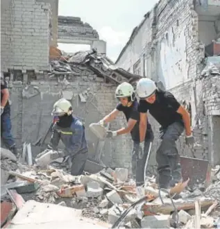  ?? // AFP ?? LOS EQUIPOS DE RESCATE RETIRAN ESCOMBROS Cientos de personas ayudan en los trabajos de retirada de cascotes del centro comercial tras el impacto de un misil ruso