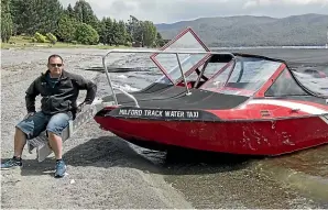  ?? BARRY HARCOURT ?? Fiordland Outdoor Company owner Mark Wallace with his twin jet water taxi that will be used for a new service offering hikers access to the Milford Track.