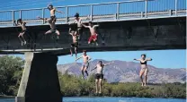  ?? PHOTO: SEAN NUGENT ?? What sign? A group of Mount Aspiring College pupils jump off the Albert Town Bridge yesterday in defiance of the signs banning people from doing so. They are (from left) Hadley Tamati (15), Micah Cousins (15) Tana Hansen (15), Dylan Rimmer (15), Kahu Nepia (15), Oliver Prince (15), Olly Thomas (16), Ethan Carleton (16) and Scarlet Norman (14).