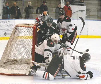  ?? [LIZ BEVAN / THE OBSERVER] ?? Elmira’s Mitch Hoelscher looks for a loose puck during a scramble in front of the Cambridge net in game action at the WMC Sunday. The Kings skated to a 4-1 victory, their third of the weekend.