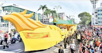  ?? - Bernama photo ?? Their majesties Kedah Sultan Sallehuddi­n Ibni Almarhum Sultan Badlishah and Sultanah Maliha Binti Almarhum Tengku Ariff on board the ‘golden barge’ in a procession from Dataran Wisma Darul Aman to Dataran Medan Besar, opposite the iconic Balai Besar (Royal Hall) in the heart of the state capital.