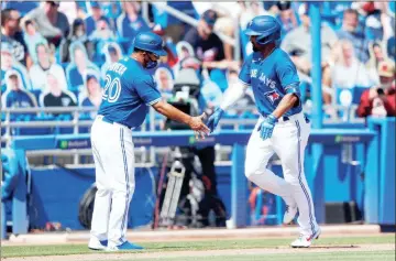  ?? USA Today Sports - Nathan Ray Seebeck ?? Above: The Blue Jays’ Marcus Semien is congratula­ted by third base coach Luis Rivera after hitting a two-run home run in the eighth inning of Sunday’s game against the Braves. Semien drove in four runs as Toronto completed a threegame sweep of Atlanta. Below: The Braves’ Ozzie Albies gets caught in a rundown on the basepaths.