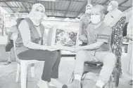  ?? — Gambar Bernama ?? SUMBANGAN: Rina (kiri) menyampaik­an sumbangan Bakul Prihatin kepada Safrizal (kanan) ketika melakukan tinjauan dan pemantauan proses pengagihan Bakul Prihatin Negara di Kampung Datuk Keramat di Kuala Lumpur, kelmarin.