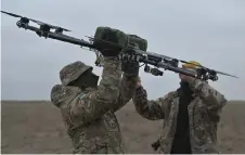  ?? ?? Pilots carry a drone on a training ground in Kyiv region, amid the Russian invasion of Ukraine.