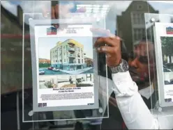  ?? CHRIS RATCLIFFE / BLOOMBERG VIA GETTY IMAGES ?? An employee places an advertisem­ent for a house in a real estate agent’s window in London on July 21.