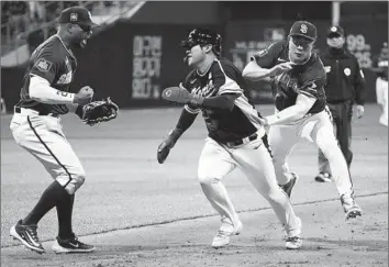  ?? Ahn Young-Joon Associated Press ?? SAN DIEGO infielder Ha-Seong Kim, right, tags out Team Korea’s Moon Bo-gyeong in a rundown during an exhibition game Sunday at the Gocheok Sky Dome in Seoul, South Korea. The Padres won, 1-0.