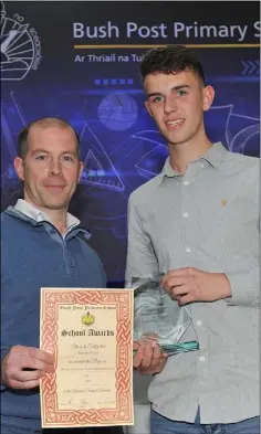  ??  ?? Brendan McCann, Highly Commended in the Oxy Arc Constructi­on Studies Award pictured receiving his award from Conor Kerrigan at the Bush Post Primary Annual School Awards for 2018.