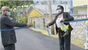  ??  ?? Custos rotulorum for Portland Lincoln Thaxter (left) and acting principal of Titchfield High School Sheryl Horne-mair officially open the newly paved Lloyd O Chin Drive at the institutio­n.