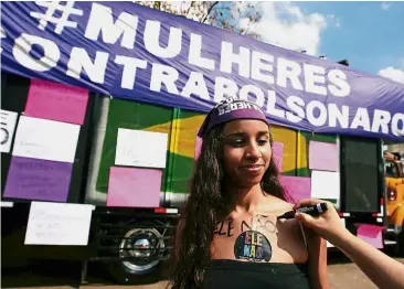  ?? — Reuters ?? Bold and beautiful:A woman getting a “#NotHim” painted on her chest during a demonstrat­ion against Bolsonaro, in Sao Paulo, Brazil. The banner in the back reads # women against Bolsonaro.”