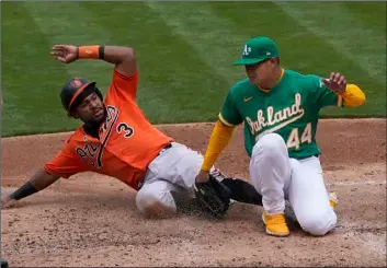  ?? AP Photo/Jeff Chiu ?? Baltimore Orioles’ Maikel Franco (3) slides home to score against Oakland Athletics pitcher Jesus Luzardo (44) during the third inning of a baseball game in Oakland, Calif., on Saturday.