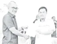  ??  ?? AHMAD (kiri) menyampaik­an surat pelantikan sebagai PT Olahraga MSSD Sandakan kepada Mohd Dani Segara dari SK Sg Anib 2, Sandakan.