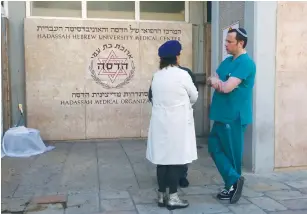  ?? (Marc Israel Sellem/The Jerusalem Post) ?? MEDICAL STAFFERS at Jerusalem’s Hadassah-University Hospital in Ein Kerem discuss yesterday’s call to strike.