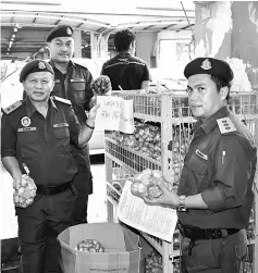  ??  ?? Kasim (left) and Ganda (right) check on the prices of garlic at one of the trading lots at the central market.