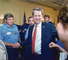  ?? HYOSUB SHIN / HSHIN@AJC.COM ?? Secretary of State Brian Kemp greets supporters at a victory party in May. Of Kemp’s supporters, roughly 15 percent said the main reason they’re backing him is because they see him as more trustworth­y.