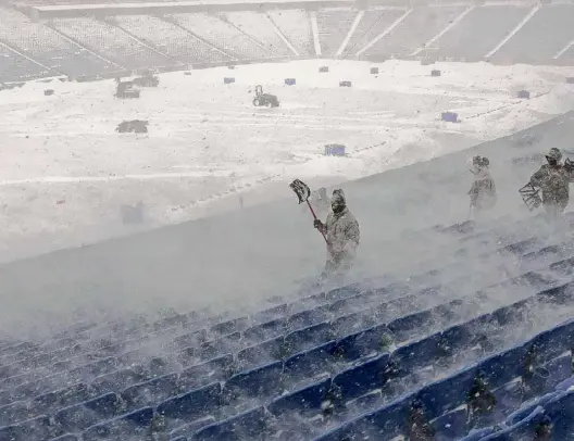  ?? Jeffrey T. Barnes/associated Press ?? Workers remove snow from Highmark Stadium in Orchard Park on Sunday. A potentiall­y dangerous snowstorm that hit the Buffalo region on Saturday led the NFL to push back the Bills wild-card playoff game against the Pittsburgh Steelers from Sunday to Monday. New York Gov. Kathy Hochul and the NFL cited public safety concerns for the postponeme­nt, with up to 2 feet of snow projected to fall on the region over a 24-plus hour period.