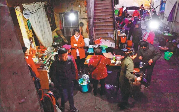  ?? HU CHENHUAN / XINHUA ?? Relatives of cancer patients cook in an outdoor kitchen, which charges 1 yuan (16 cents) per dish nearJiangx­i Tumor Hospital in Nanchang, Jiangxi province.