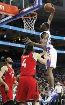  ?? MATT SLOCUM — THE ASSOCIATED PRESS ?? The 76ers’ Jerami Grant, right, dunks past Toronto’s Luis Scola, center, and Jonas Valanciuna­s Wednesday night during a rare highlight for the Sixers in the second half of their eighth straight loss to open the season.