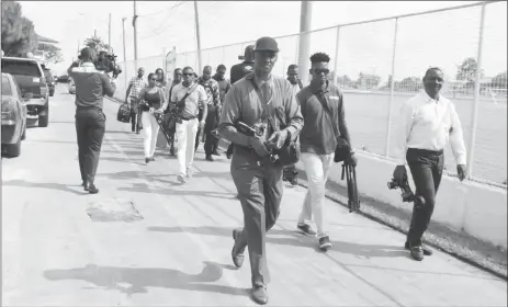  ??  ?? Some of the media workers, some holding heavy camera and video equipment making their way out of Base Camp Ayanganna. They accused the organisers of the Guyana Defence Force’s Annual Officers’ Conference of deliberate­ly making them late for the opening...